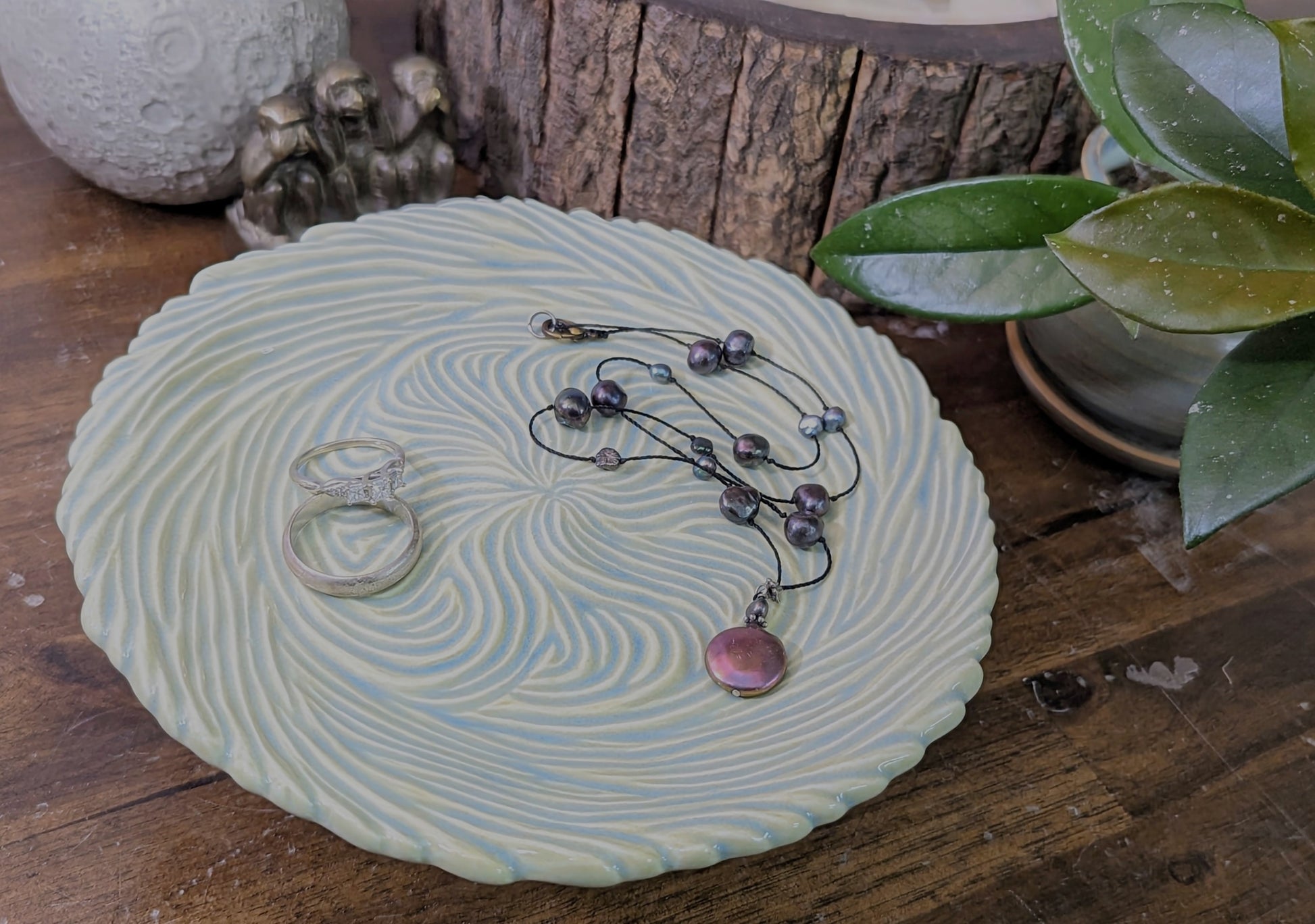 A Portal plate in Celadon Swirls holding 2 rings and a necklace